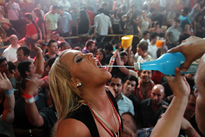Девушка ловит ртом струю алкоголя