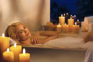Девушка отдыхает в ванне при свечах
