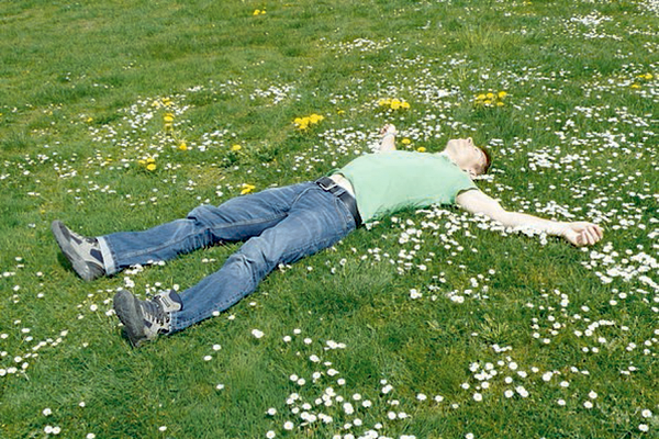 Мужчина лежит на траве и смотрит в небо